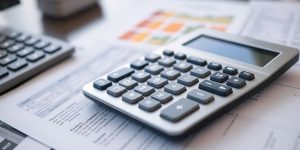 Calculator and financial documents on a desk.